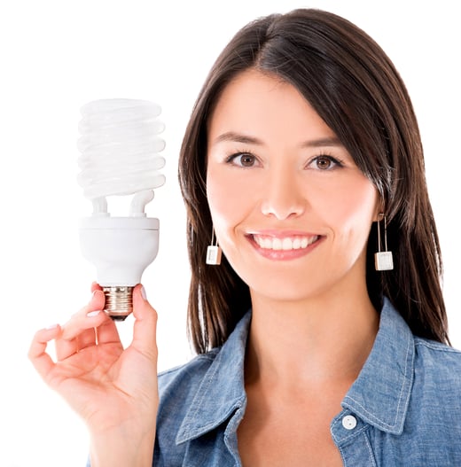 Happy woman with an energy saving bulb - isolated over white background