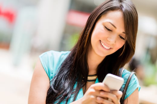 Portrait of a woman sending text message from her phone